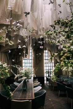 a dining room filled with lots of tables covered in paper cranes hanging from the ceiling