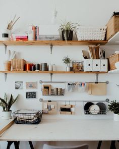 a white desk topped with lots of shelves filled with books and office supplies on top of it