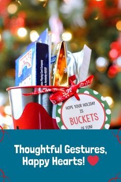 a bucket filled with lots of gifts sitting in front of a christmas tree that says thoughtful gestures, happy hearts