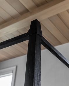 a close up of a wooden cross on a pole in a room with wood ceilinging