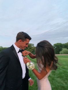 a bride and groom are standing in the grass