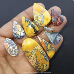 a hand holding some yellow and black marbles on it's thumbnails