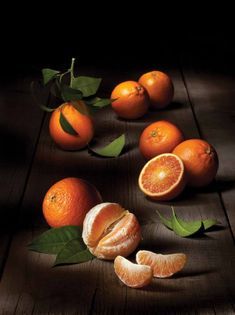 oranges and leaves on a wooden table