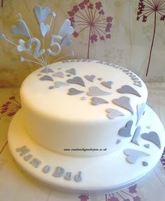 a white cake with silver hearts on it