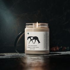 a candle with a horse on it sitting on a table next to other items and candles