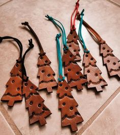 five wooden christmas trees are hanging on a tile floor