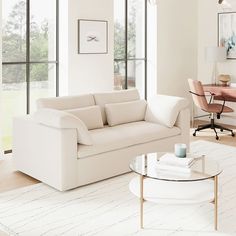 a living room filled with furniture next to large windows and a rug on the floor