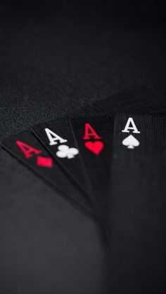 four playing cards sitting on top of each other