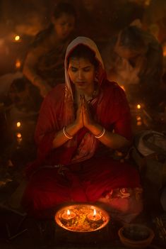 a woman sitting on the ground with her hands together