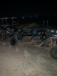 two off - road vehicles parked in the dirt at night