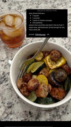 a bowl filled with meat and vegetables next to a drink