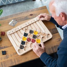 an older man is playing with his wooden board game, which includes pieces of wood