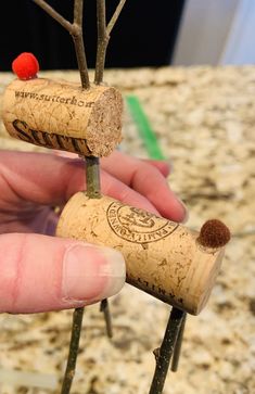 someone is holding two wine corks in their hand and they are made to look like trees