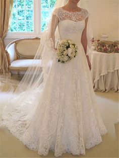 a woman in a wedding dress standing next to a window