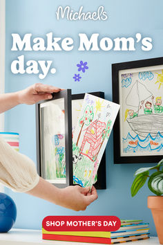 a mother's day card is being held up by her child in front of a blue wall