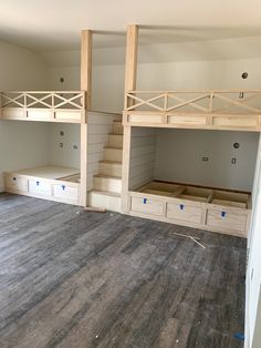 an empty room with bunk beds and drawers