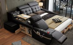 a black leather reclining bed with pillows on it