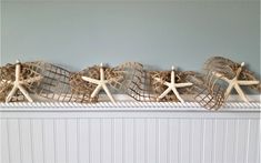 three starfish and two seashells on a mantle