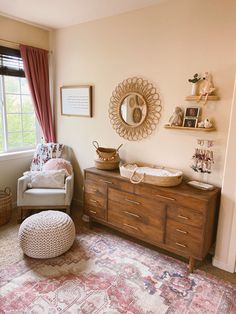 a baby's room with a crib, dresser and chair in it that has a large rug on the floor