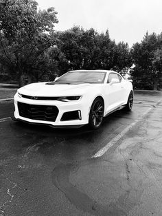 a white chevrolet camaro parked in a parking lot