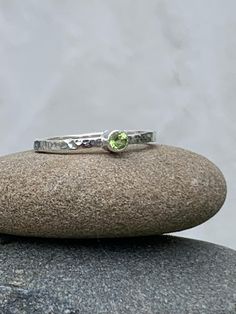 Sterling silver 2mm wide  stacking ring with a textured finish and set with a vibrant green natural semi precious Peridot. Available made to order in a variety of sizes. Handmade at my studio in Falmouth. Packaged in a presentation box and organza bag. Delivered free of charge within the UK. Green Peridot Stackable Rings, Green Peridot Stackable Promise Rings, Green Sterling Silver Stackable Rings, Green Sterling Silver Stackable Rings With Round Band, Handmade Green Stackable Rings For May Birthstone, Green Stackable Sterling Silver Rings, Handmade Silver Ring, Falmouth, Silver Rings Handmade