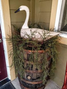 a swan statue sitting on top of a wooden barrel