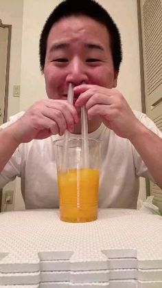 a man drinking orange juice from a blender