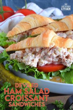 a close up of a sandwich on a plate with lettuce and tomatoes in the background