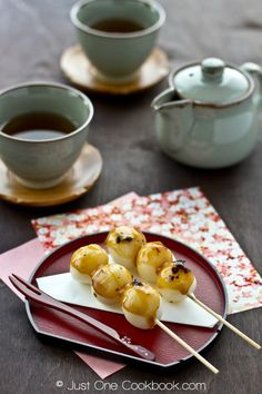 some food is sitting on a plate with chopsticks and saucers next to it