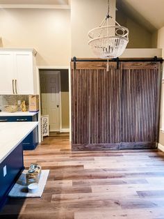 an empty kitchen with wooden floors and sliding doors in the middle, next to a counter top