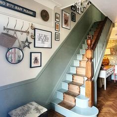 there is a staircase in the house with pictures on the wall above it and below it