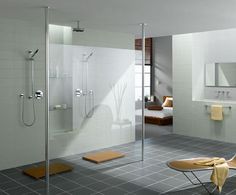 a modern bathroom with white walls and tile flooring, including a walk in shower