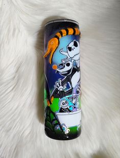 a can that is sitting on top of a white fur covered surface with a cartoon character painted on it