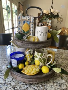 two tiered trays filled with lemons and tea cups on top of a counter