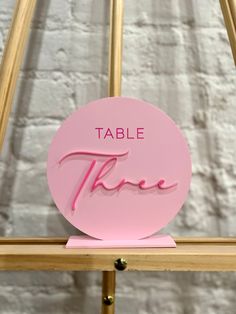 a pink table sign that says table three on it