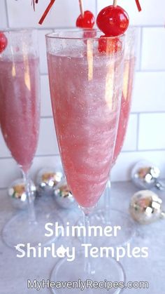 two glasses filled with pink liquid and topped with cherries