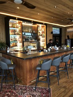 a bar with several chairs and a rug on the floor