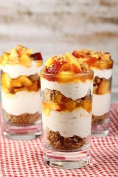 three desserts in small glass dishes on a red and white checkered tablecloth