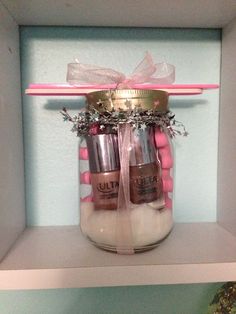 two jars filled with different types of nail polish on top of a shelf next to a potted plant