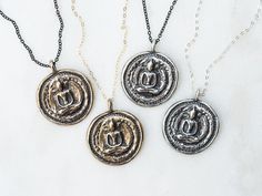 "Thai Buddha Coin Necklace These funky pendants will become your new favorite everyday piece of jewelry! They are modeled after an antique Buddha coin I've had for many years and have cherished. You can customize your necklace by choosing the pendant metal, chain color and length. All pendants are antiqued with a black patina to keep the antique and rustic feel. The original prototype was first carved out of bronze metal clay and then fired in a kiln until only solid metal remained. Each of thes Black Spiritual Jewelry With Antique Finish, Spiritual Antique Silver Necklaces With Antique Finish, Spiritual Hand Forged Medallion Necklaces, Spiritual Hand Forged Medallion Necklace, Symbolic Pendant Necklaces With Antique Finish, Antique Finish Round Pendant Spiritual Jewelry, Spiritual Necklace With Antique Finish Round Pendant, Spiritual Necklaces With Antique Finish Round Pendant, Spiritual Antique Finish Round Pendant Necklace