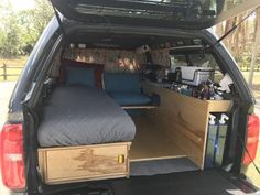 the back end of a van with an open bed and storage area in the trunk