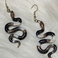 Do you love snakes, or just tender earrings? These hand crafted earrings are the cutest! Made from the strongest materials, including epoxy resin and stainless steel,  they will last for longer than even most metals do. They aren't brittle or easily broken even though they appear to be dainty when you are wearing them, makes these earrings a perfect choice to gift to preteens and adults alike.  They can withstand many situations without fear of then breaking! There dangles are sure to become your favorite go to for style and comfort! Handmade Snake Shape Earrings, Snake-shaped Earrings For Gifts, Handmade Snake-shaped Earrings As Gift, Snake-shaped Earrings With Ear Wire For Gift, Snake-shaped Earrings With Ear Wire As Gift, Snake-shaped Pierced Earrings Gift, Snake-shaped Pierced Earrings For Gift, Snake-shaped Single Earring As Gift, Snake-shaped Earrings For Pierced Ears As Gift