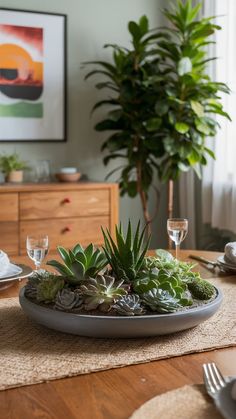 there is a plate with succulents on the table next to a potted plant