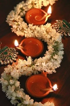 three candles are lit in front of some flowers