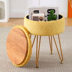 a small yellow table with some books on it and a plant in the middle of it