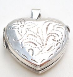 Italian Jewelry - This is a sterling silver heart locket picture pendant with a floral etch design. It is hallmarked 925 Italy, maker's mark with M in square. The pendant measures 1.25" by 1", weighs 6.4 grams, opens and closes properly, still has plastic inserts to cover photos. There are light surface scratches on the back. Locket Picture, Silver Heart Locket, Picture Pendant, Etched Designs, Italian Jewelry, Maker's Mark, Heart Locket, Sterling Silver Heart, Vintage Italian