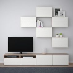 an entertainment center with shelving units and a flat screen tv mounted on the wall