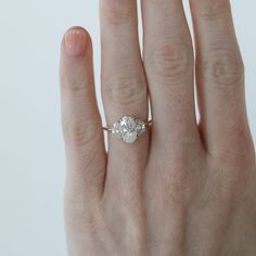 a woman's hand with an engagement ring on it