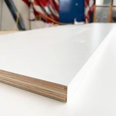 white plywood boards stacked on top of each other in a room with an american flag in the background