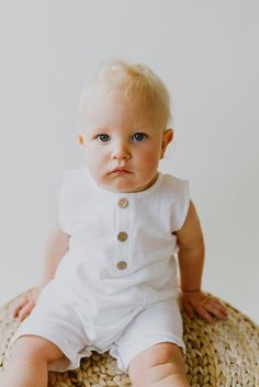 Our White Sleeveless Crop Linen Baby Romper is the cutest, light weight piece for warmer months! Bottom snaps and functioning buttons on front. Made with Linen. White Cotton Vest With Buttons, White Sleeveless Bubble Romper For Playtime, Playful White Sleeveless Bubble Romper, Playful Sleeveless White Bubble Romper, Cute Cotton Bubble Romper With Buttons, Summer Cotton Bubble Romper With Button Closure, White Button Tops For Playtime, White Buttoned Tops For Playtime, Summer Buttoned Playwear Tops